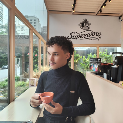 Foto do Diogo segurando uma xícara de café.